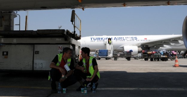 Sıcaktan bunalan işçiler uçakların altında serinledi