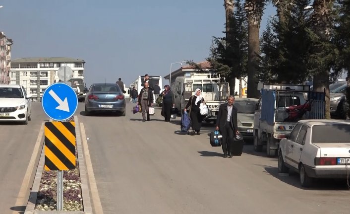 Yerle bir olan şehri otobüslerle terk ediyorlar...