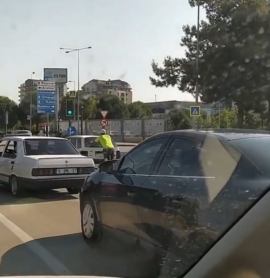 Bursa'da trafik polisi yolda kalan otomobili iterek, sürücüye yardım etti